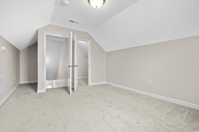 additional living space featuring light carpet and vaulted ceiling