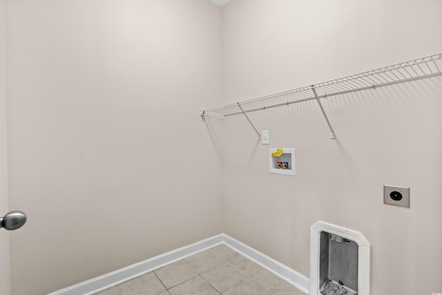 clothes washing area with electric dryer hookup, light tile patterned floors, and washer hookup