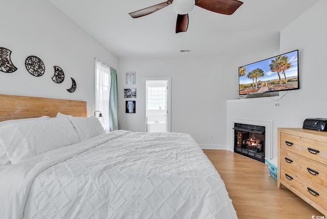 bedroom with connected bathroom, ceiling fan, and light wood-type flooring