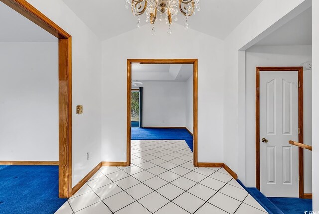 hallway featuring a notable chandelier, lofted ceiling, and light tile patterned floors