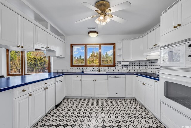 kitchen featuring white cabinets, ceiling fan, decorative backsplash, and white appliances