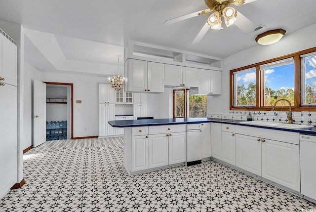 kitchen with white cabinetry, sink, dishwasher, and ceiling fan with notable chandelier