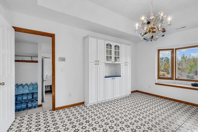 unfurnished dining area featuring a notable chandelier