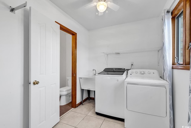 washroom with washing machine and clothes dryer, ceiling fan, light tile patterned floors, and water heater