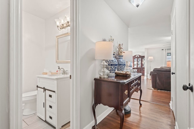 1673 Middleton St, Georgetown, SC 29440 - hall with a sink, light wood finished floors, and a chandelier