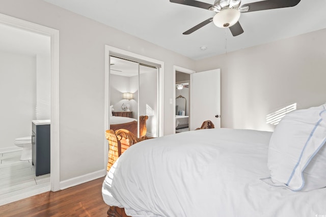 bedroom featuring ceiling fan, ensuite bath, dark hardwood / wood-style floors, and a closet