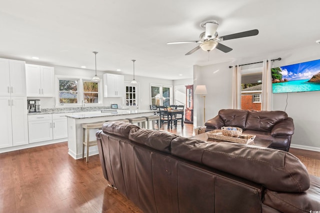 living room featuring ceiling fan, dark hardwood / wood-style flooring, and sink