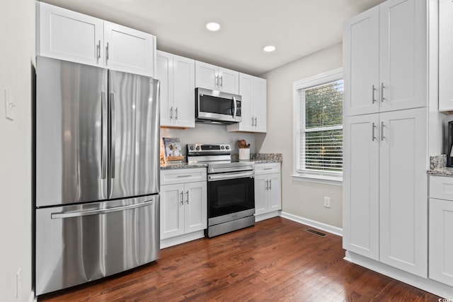 kitchen featuring stainless steel appliances, light stone countertops, and white cabinets