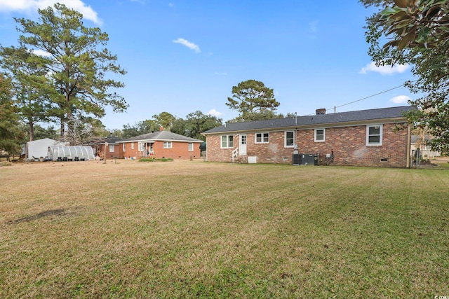 1673 Middleton St, Georgetown, SC 29440 - rear view of property featuring crawl space, brick siding, a lawn, central AC, and a chimney