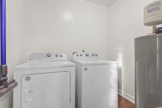 laundry area featuring water heater, dark hardwood / wood-style flooring, and independent washer and dryer