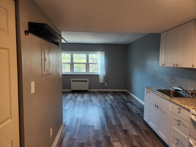 kitchen with white cabinets, light stone counters, sink, and dark wood-type flooring