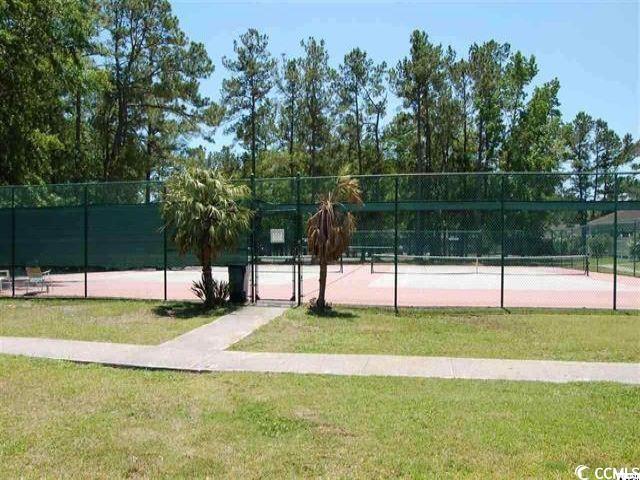 view of sport court featuring a lawn