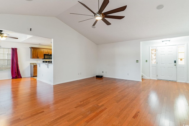 unfurnished living room featuring light wood-type flooring, vaulted ceiling, and ceiling fan