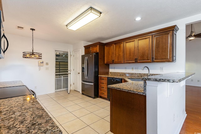 kitchen with sink, dishwasher, stainless steel fridge with ice dispenser, dark stone countertops, and decorative light fixtures