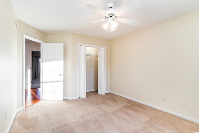 unfurnished bedroom featuring ceiling fan, light carpet, and a closet