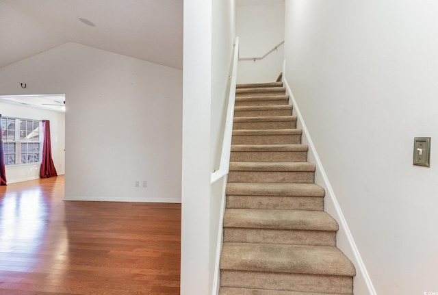 stairway with hardwood / wood-style floors, ceiling fan, and vaulted ceiling