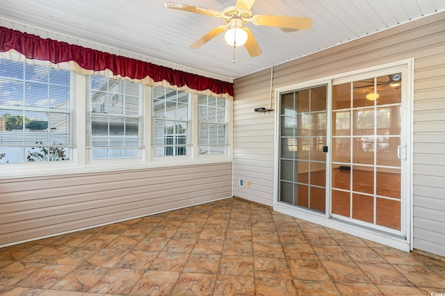 unfurnished sunroom featuring ceiling fan and a healthy amount of sunlight