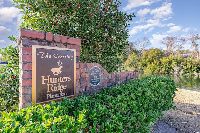 community sign featuring a water view