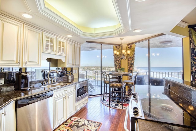 kitchen featuring a water view, sink, crown molding, appliances with stainless steel finishes, and wood-type flooring