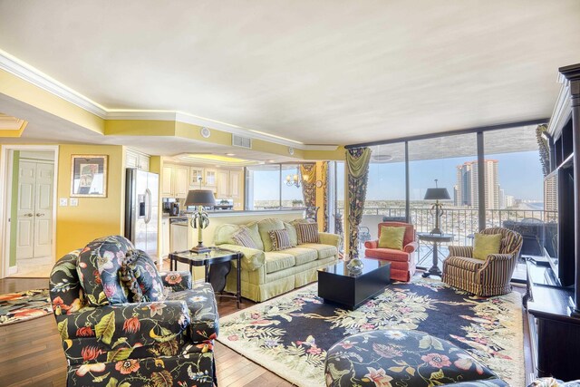 living room with hardwood / wood-style floors, expansive windows, and ornamental molding