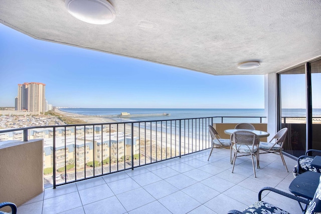 balcony featuring a water view and a beach view