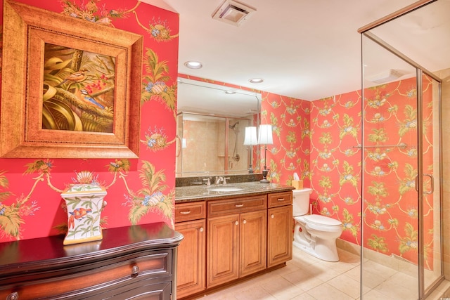 bathroom with tile patterned flooring, vanity, toilet, and a shower with shower door