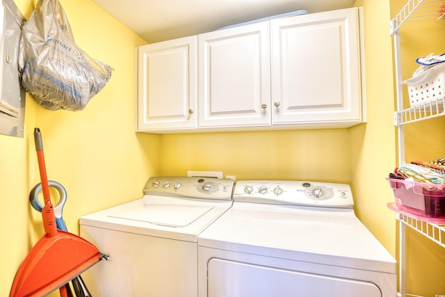 clothes washing area featuring cabinets and washer and dryer