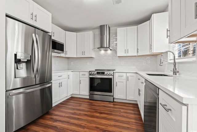 kitchen with wall chimney range hood, sink, appliances with stainless steel finishes, and dark wood-type flooring