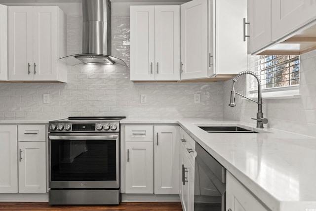 kitchen featuring sink, stainless steel appliances, wall chimney range hood, tasteful backsplash, and white cabinets