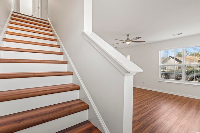 stairs featuring ceiling fan and wood-type flooring