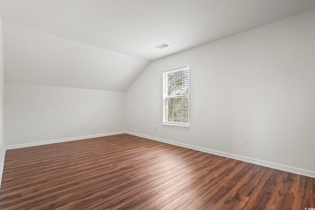 additional living space featuring dark hardwood / wood-style floors and lofted ceiling