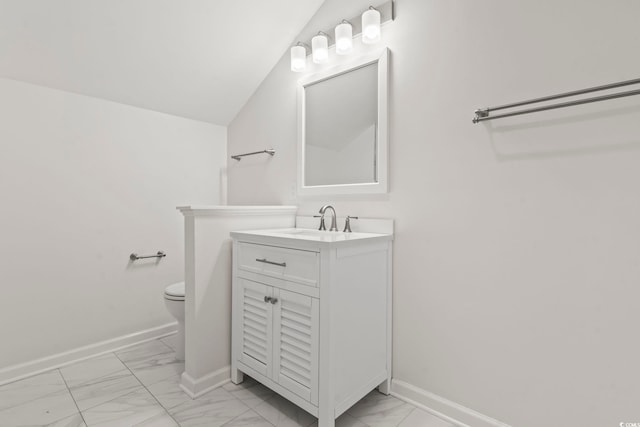 bathroom with vanity, toilet, and lofted ceiling