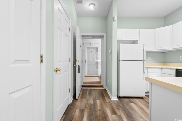 kitchen with white cabinets, dark hardwood / wood-style floors, and white refrigerator