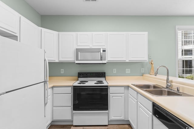 kitchen featuring white cabinets, appliances with stainless steel finishes, and sink