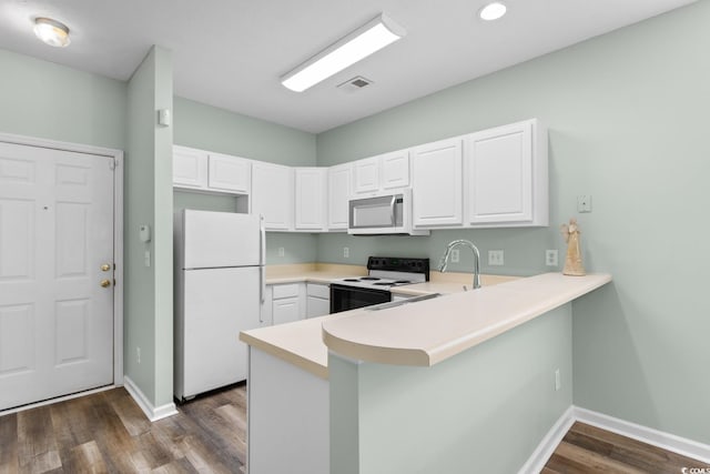 kitchen featuring kitchen peninsula, white appliances, dark hardwood / wood-style floors, and white cabinetry