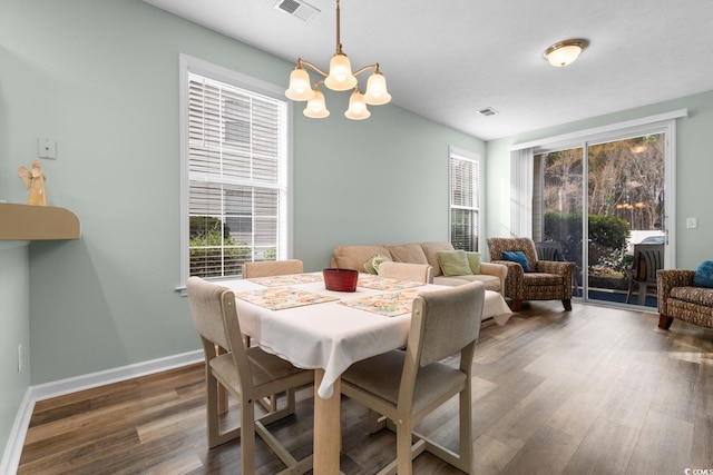 dining area featuring dark hardwood / wood-style floors and a notable chandelier