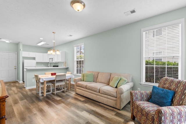 living room featuring light hardwood / wood-style floors and an inviting chandelier