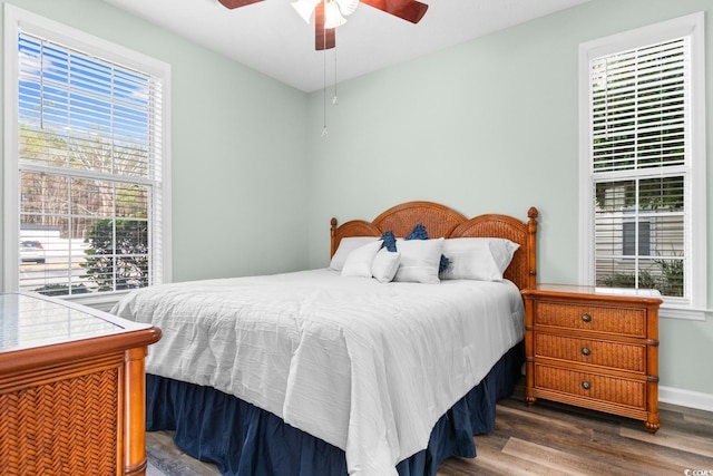 bedroom with dark hardwood / wood-style flooring and ceiling fan