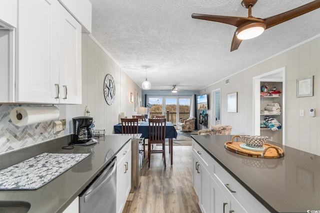 kitchen with light hardwood / wood-style flooring, stainless steel dishwasher, ceiling fan, decorative light fixtures, and white cabinetry