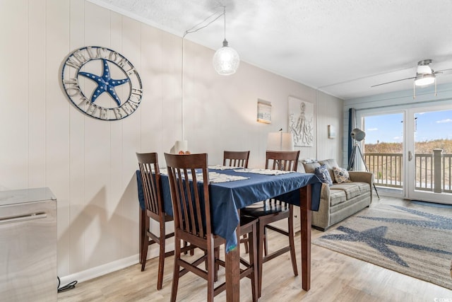 dining space with ceiling fan, light hardwood / wood-style floors, and a textured ceiling