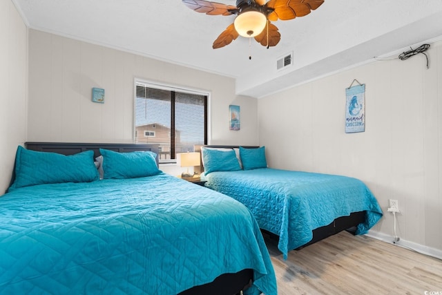 bedroom with light hardwood / wood-style floors, ceiling fan, and ornamental molding