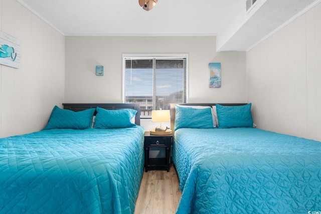 bedroom featuring light hardwood / wood-style flooring and ornamental molding