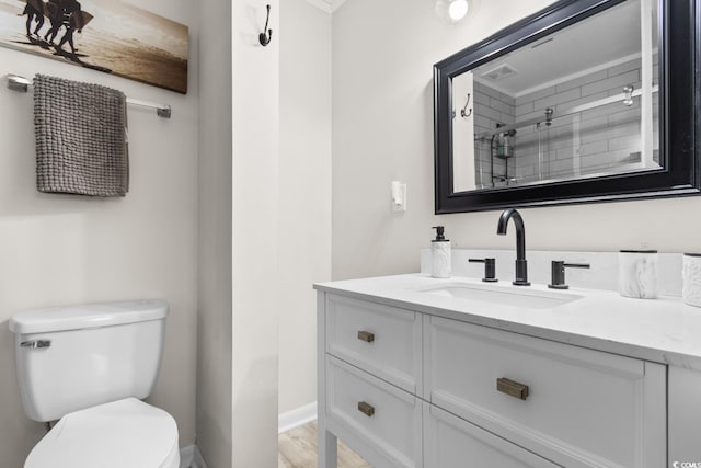 bathroom featuring walk in shower, hardwood / wood-style floors, vanity, and toilet