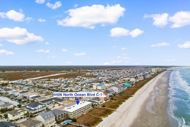 birds eye view of property featuring a beach view and a water view