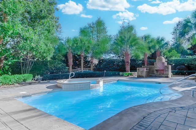 view of swimming pool with a patio area, an in ground hot tub, and an outdoor fireplace