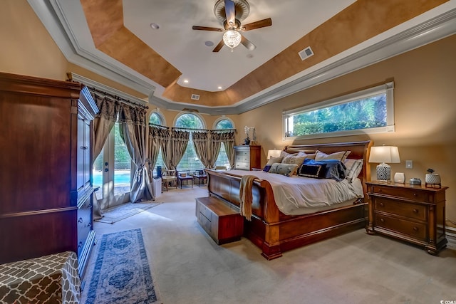 carpeted bedroom featuring access to exterior, a tray ceiling, ceiling fan, and ornamental molding