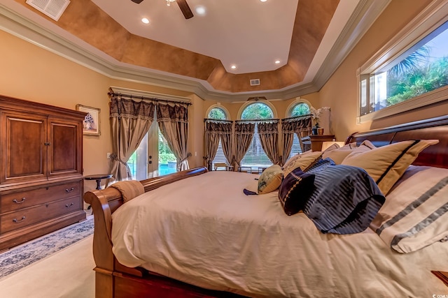 carpeted bedroom with a tray ceiling, access to exterior, and multiple windows