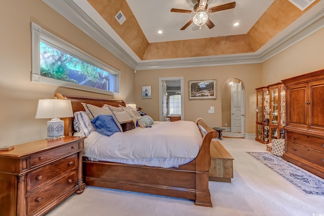 carpeted bedroom featuring ceiling fan, a raised ceiling, and multiple windows