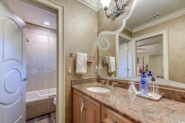 full bathroom with vanity, tile patterned floors, tiled shower / bath combo, toilet, and ornamental molding