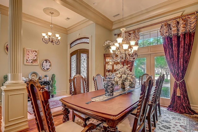 dining area featuring french doors, ornate columns, ornamental molding, an inviting chandelier, and light hardwood / wood-style floors